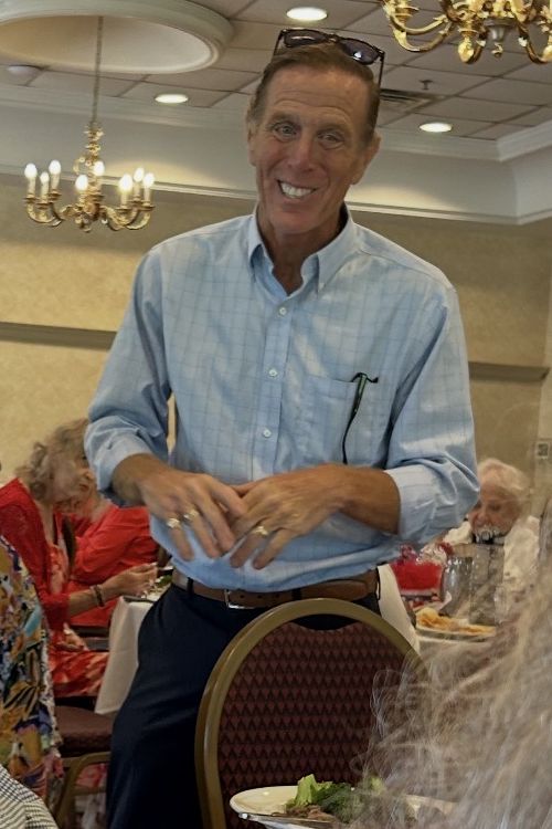 Mike Ramone smiling and talking with guests at a Kent County luncheon.