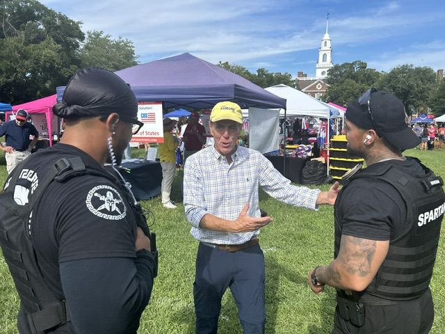Mike Ramone talking with two uniformed officers at the festival.
