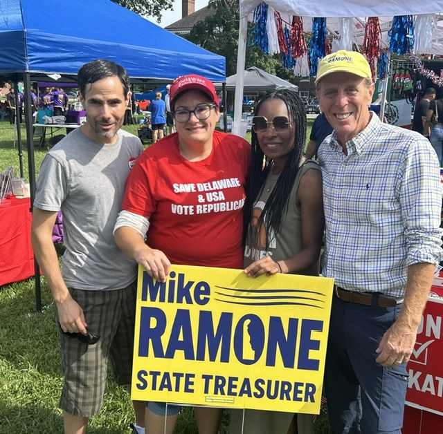 Mike Ramone with supporters holding a Mike Ramone State Treasurer yard sign.