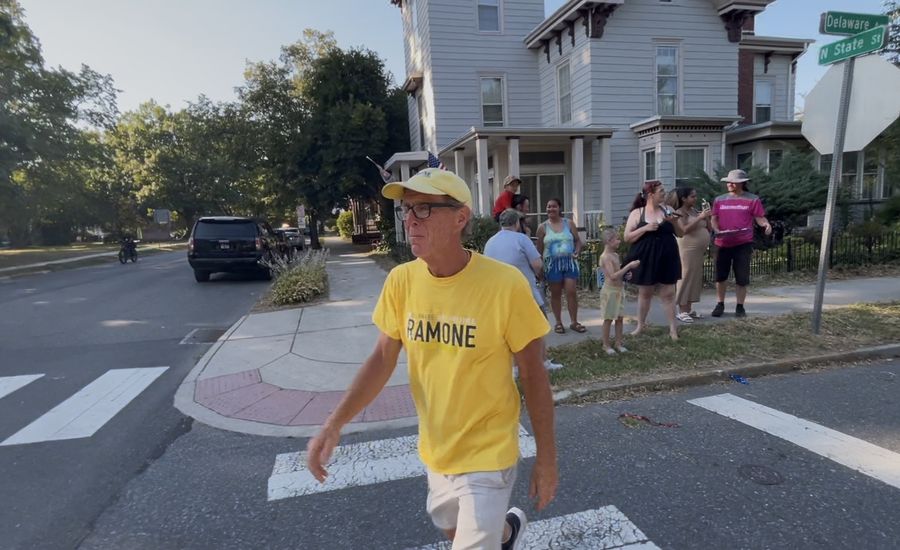 Mike Ramone in a yellow Ramone T-shirt and cap walking the Dover parade route.